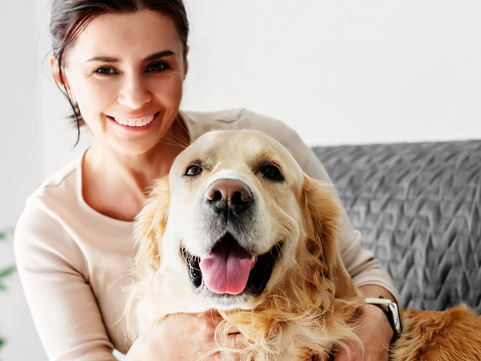girl hugging golden retriever dog smiling